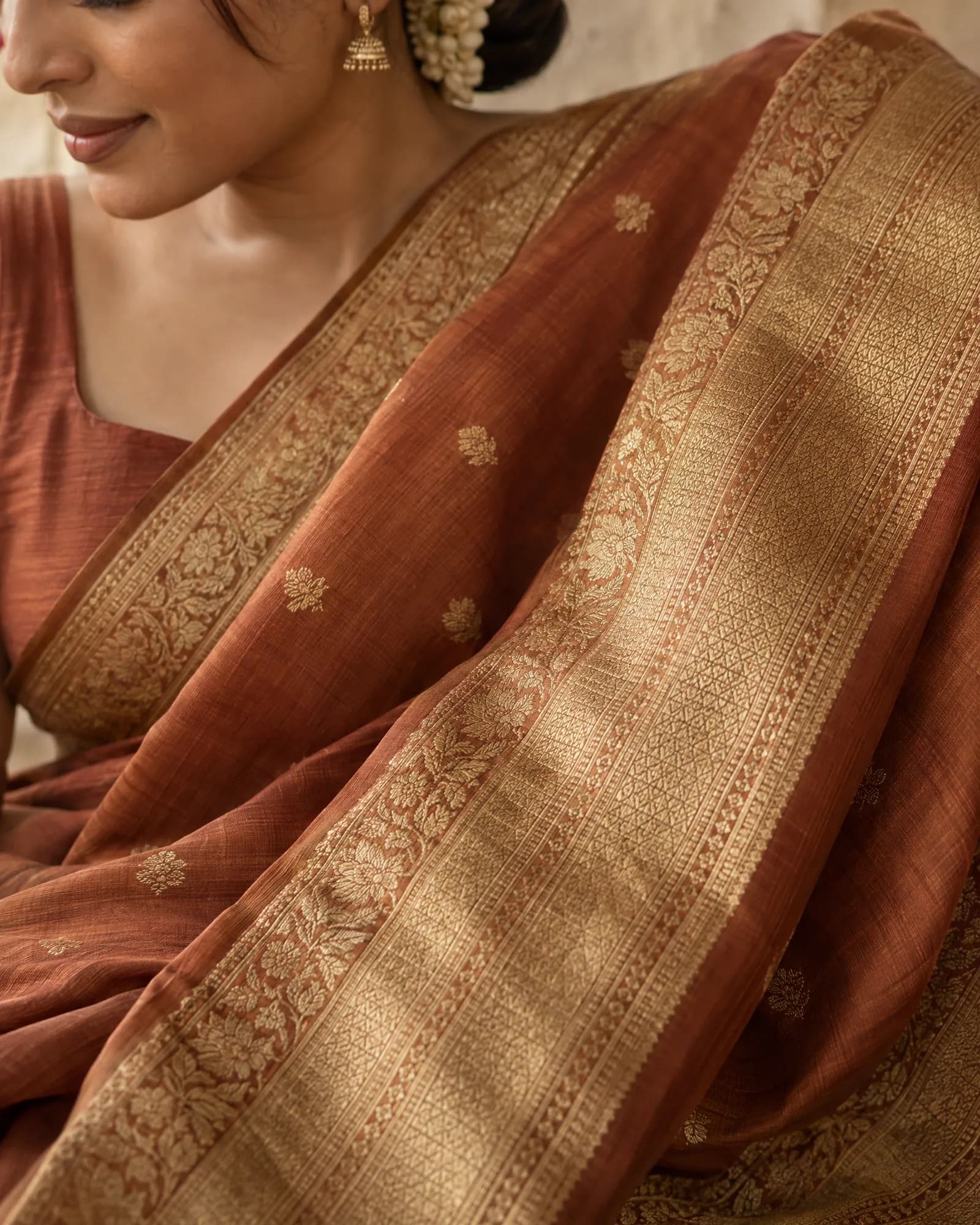 Close-up of the saree's gold zari border (Helium-made example)