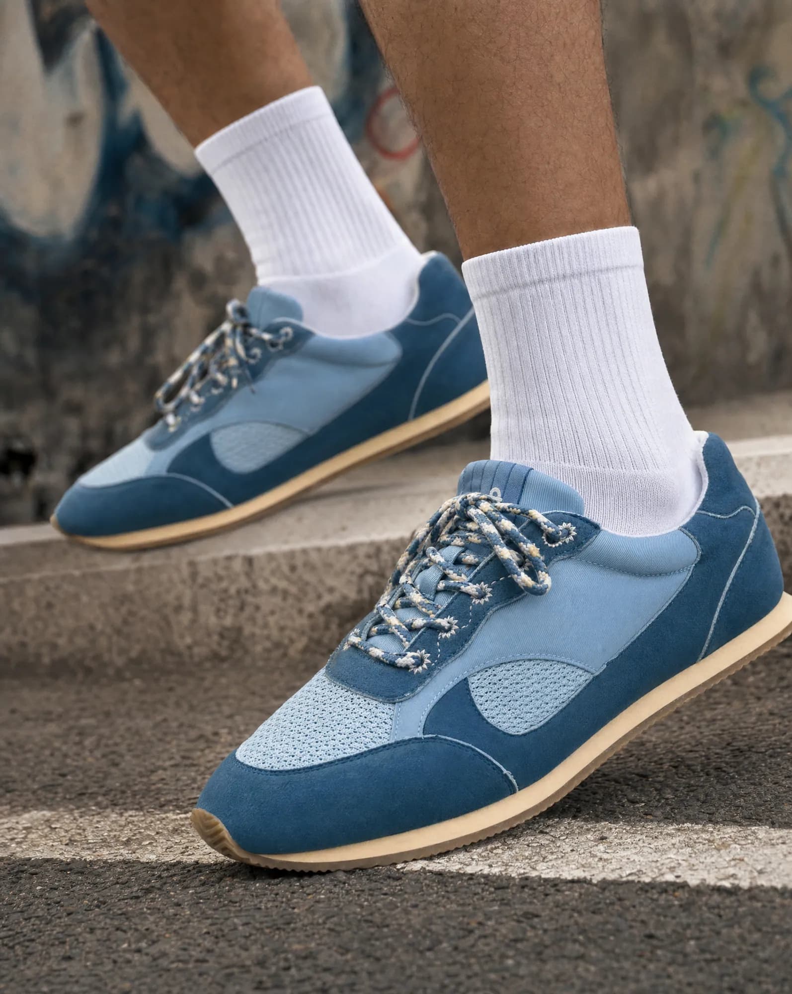 After: AI on-feet shot of the sneakers on a city step