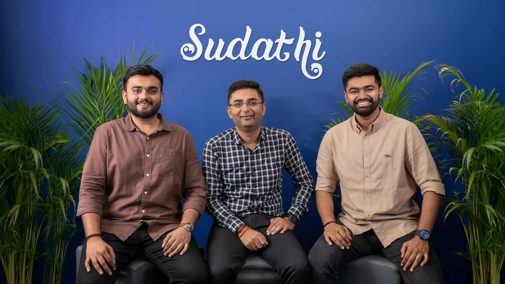 The Sudathi team in front of the Sudathi logo